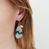 Rockpool large beach sand and blue resin dangle earrings on model left.